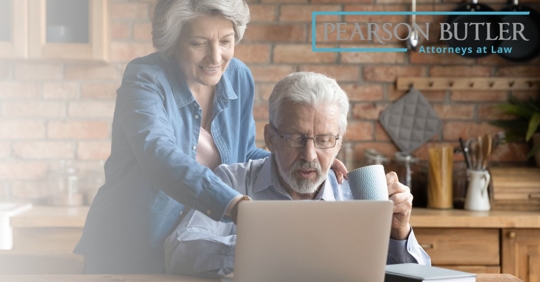 Older man and woman looking at a laptop in their kitchen