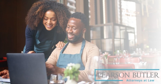 Two small business owners happily working on a laptop