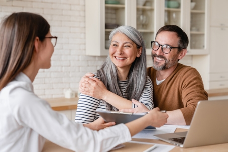 happy couple looking over documents with a lawyer