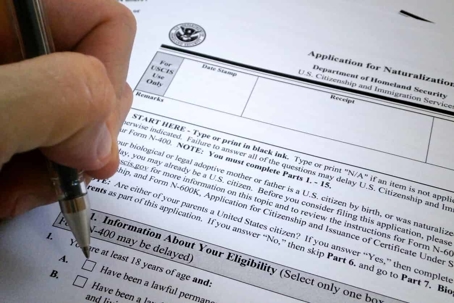 close up of person filling out an application for naturalization