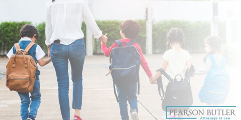 little girl looking at cutouts of a family