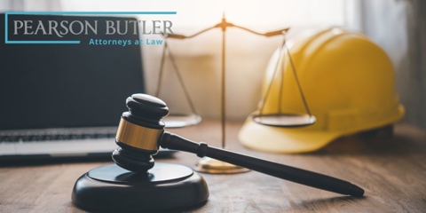 hard hat on table with computer, gavel, and scales