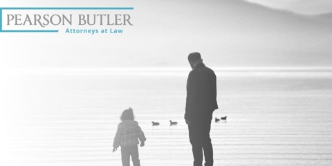Child and parent standing in front of a lake.