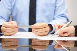 man holding a pen and signing papers