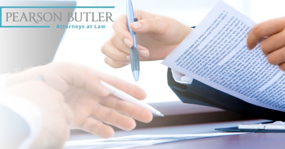 Person signing papers with pen