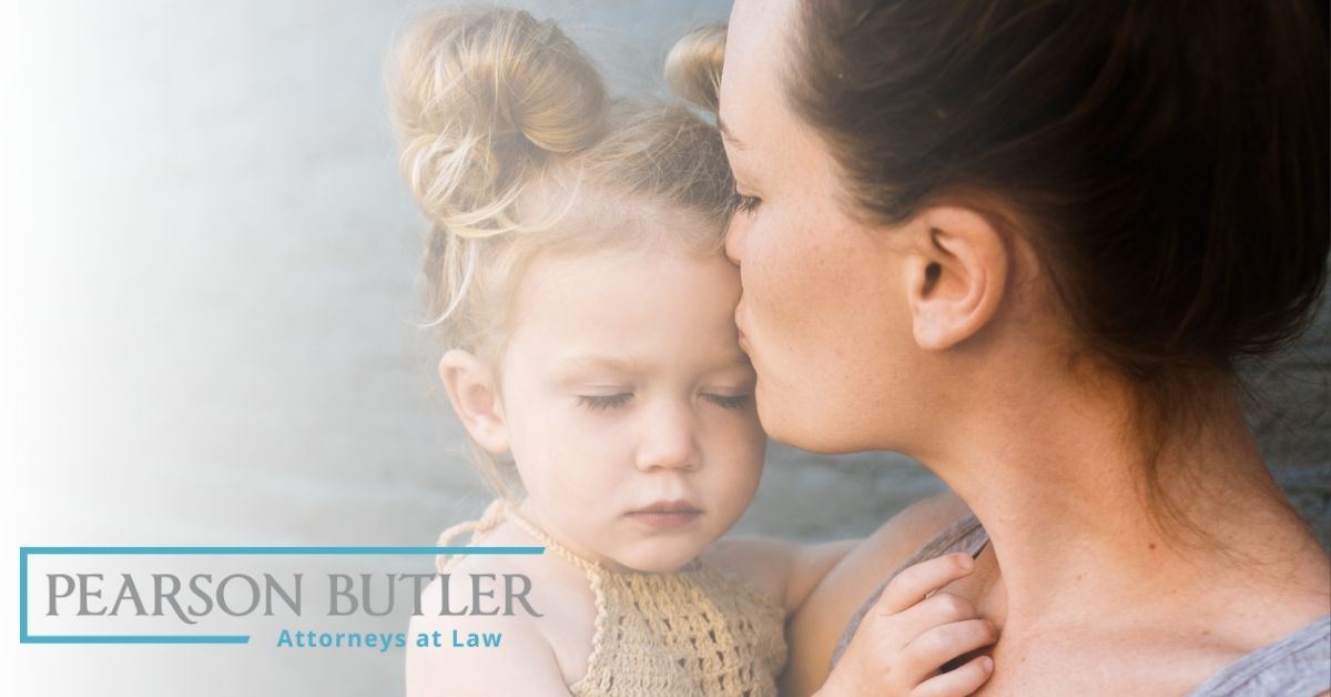 Mother giving her daughter a kiss on the forehead