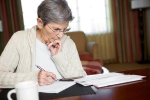Elderly woman looking at paperwork